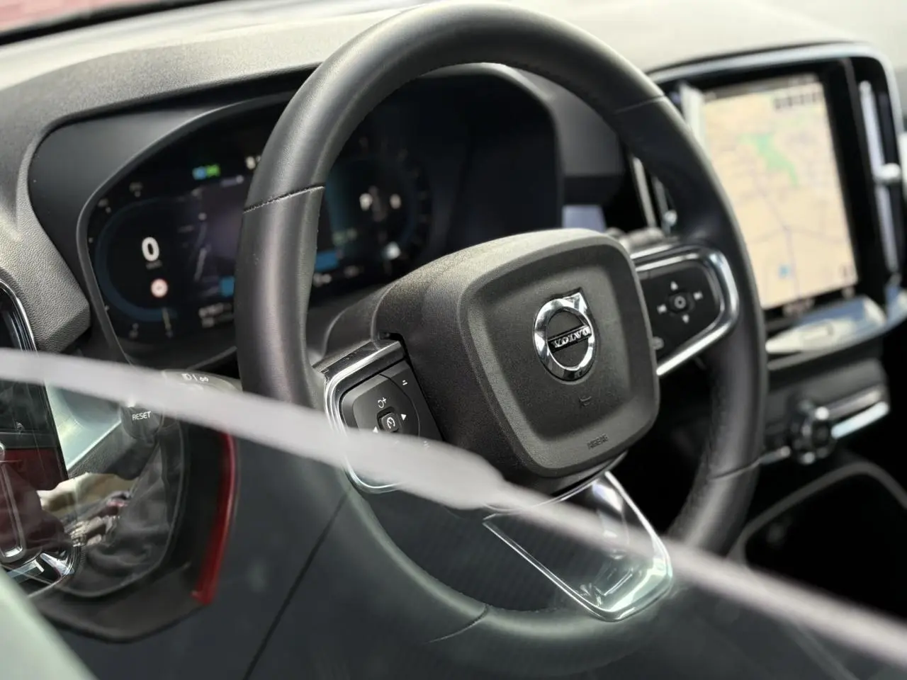 Gros plan sur le volant noir et le tableau de bord digital du Volvo XC40 B3 MHEV 2024 avec écran tactile GPS.