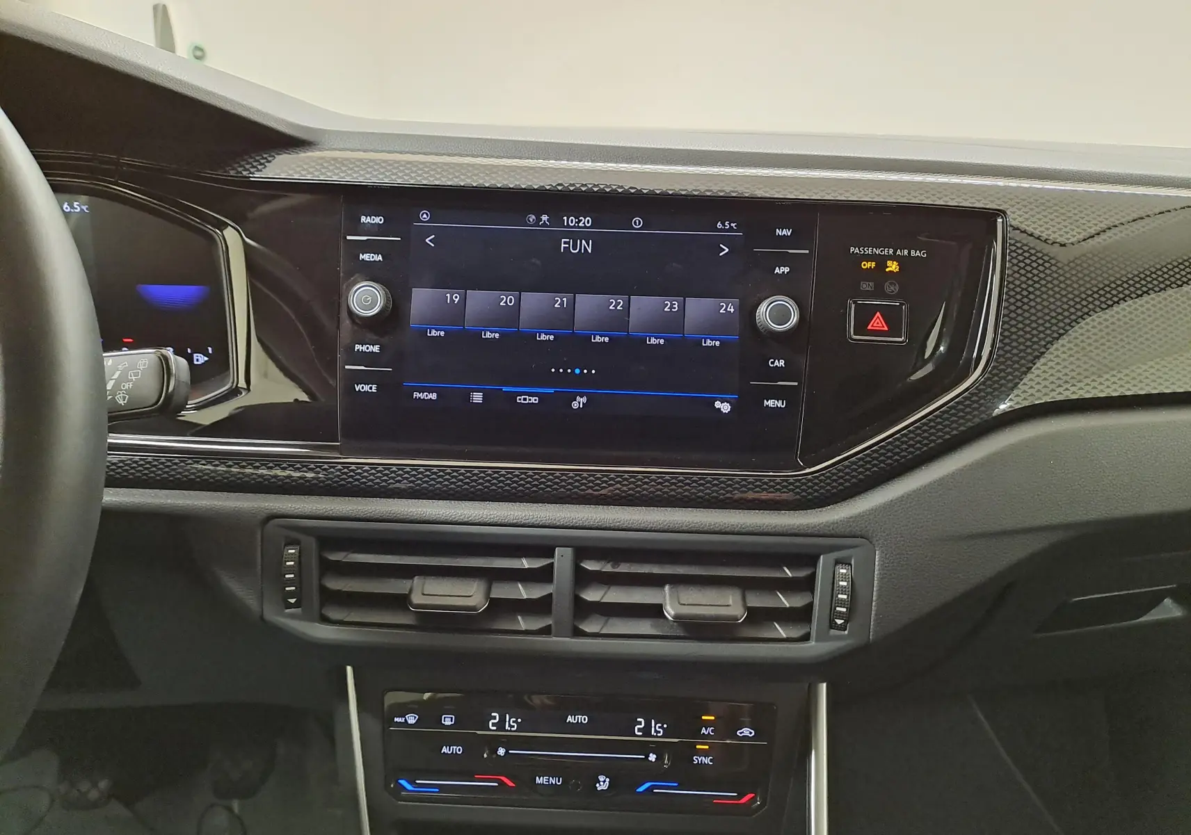 Vue rapprochée du tableau de bord du Volkswagen Taigo 2024 avec écran tactile et commandes de climatisation bi-zone.