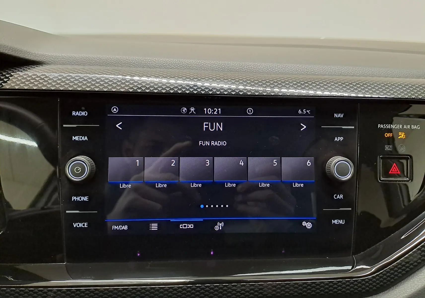 Écran tactile central du Volkswagen Taigo 2024 affichant la radio FUN, entouré de commandes noires brillantes.