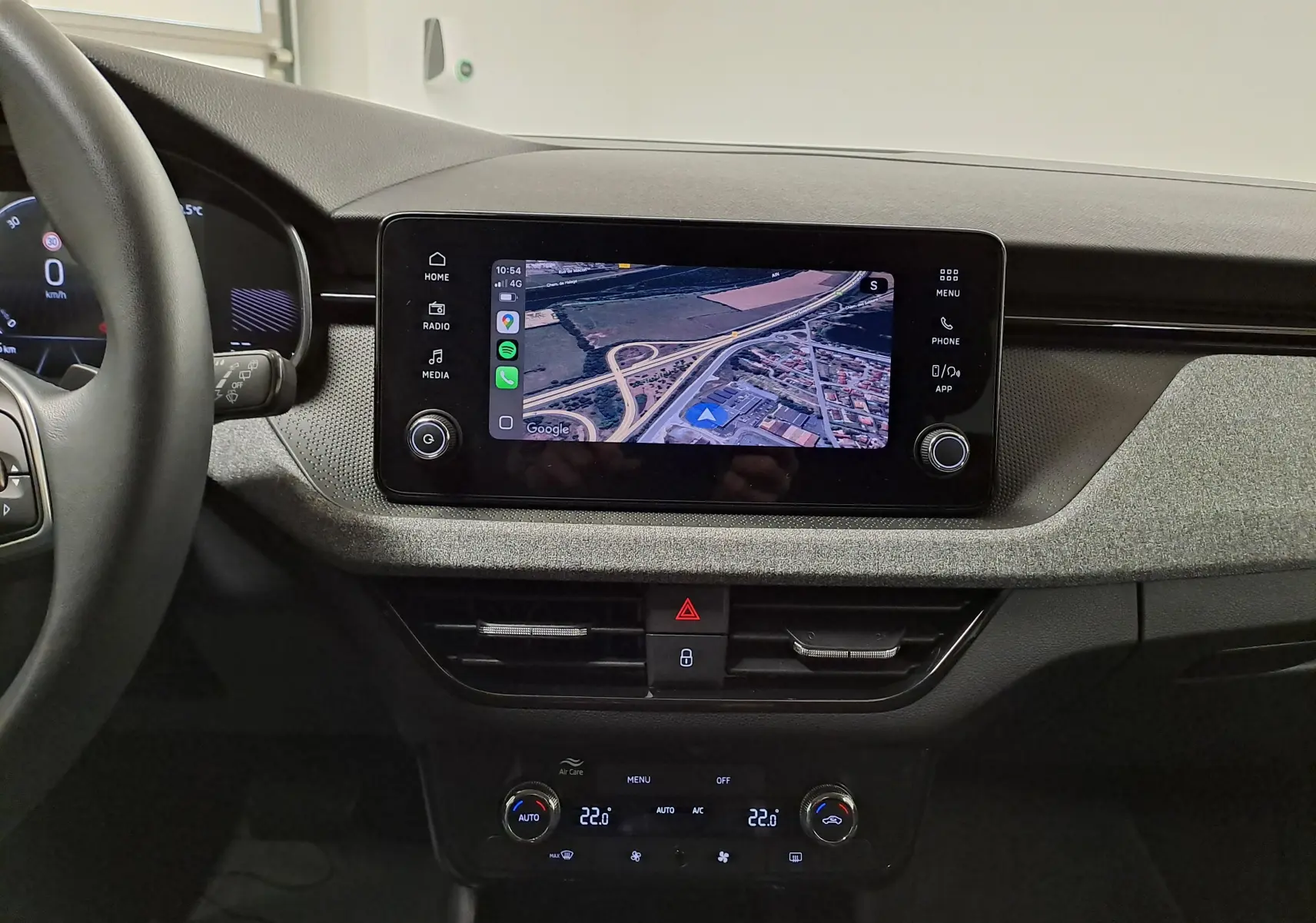 Vue intérieure du tableau de bord de la Skoda Scala 2025 avec écran tactile affichant la caméra de recul et commandes climatisation.