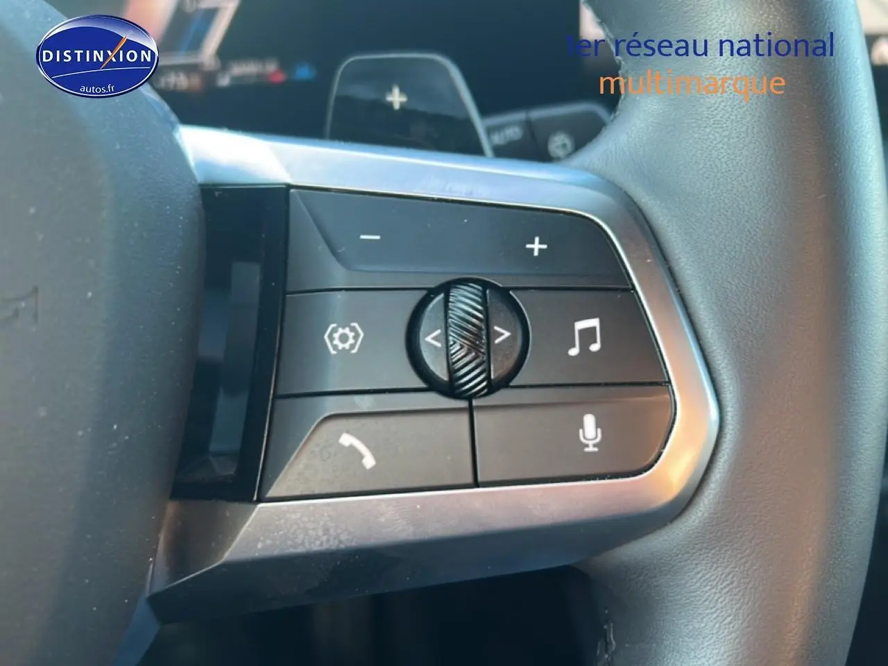 Gros plan sur les commandes multifonctions au volant d’une BMW Série 1 gris Skyscraper, version 118da M Sport Pro.