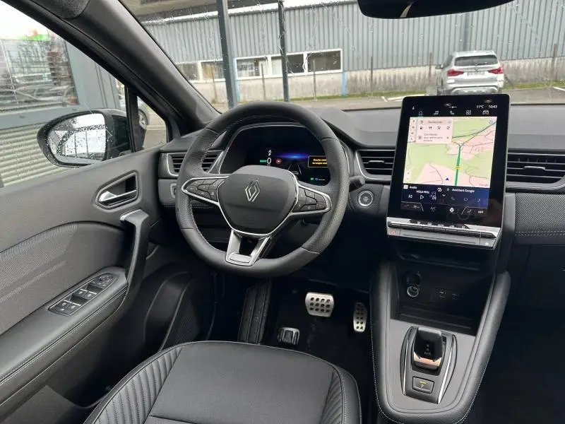 Vue intérieure côté conducteur du Renault Captur 1.8 E-Tech hybride 2026, avec volant multifonction et écran tactile vertical.