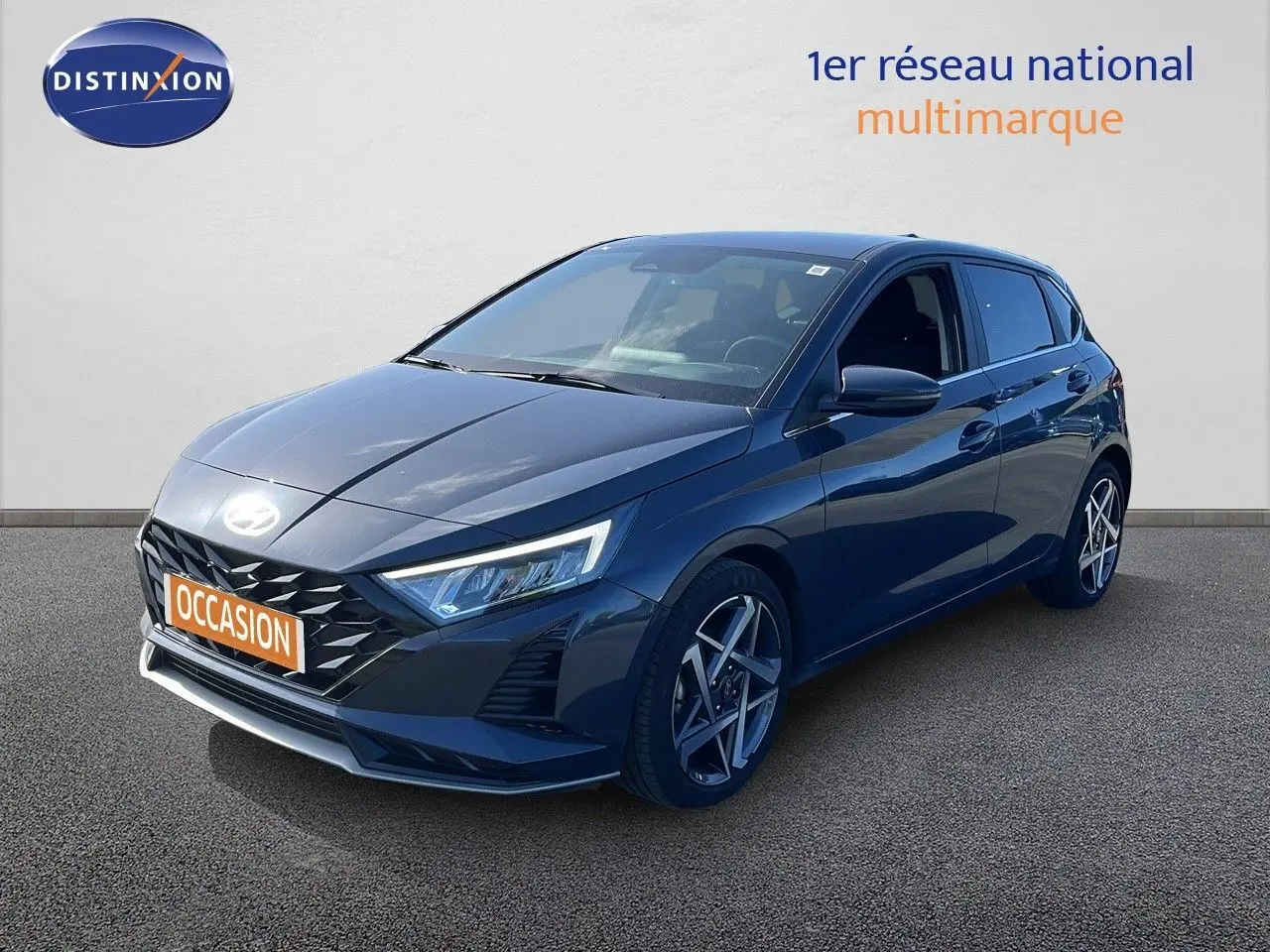 Hyundai i20 gris Aurora métal vue 3/4 avant droit avec jantes alliage et calandre noire distinctive.