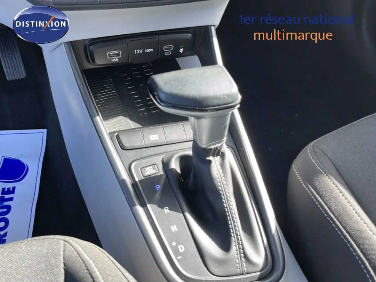 Gros plan sur la console centrale de la Hyundai i20 2025, montrant le levier de vitesse automatique et les ports USB en finition gris aurora metal.