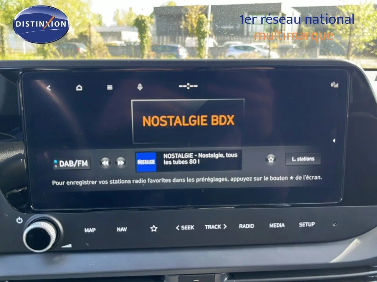 Vue rapprochée de l’écran tactile intérieur d’une Hyundai i20 2025 gris Aurora Metal affichant la radio Nostalgie BDX.