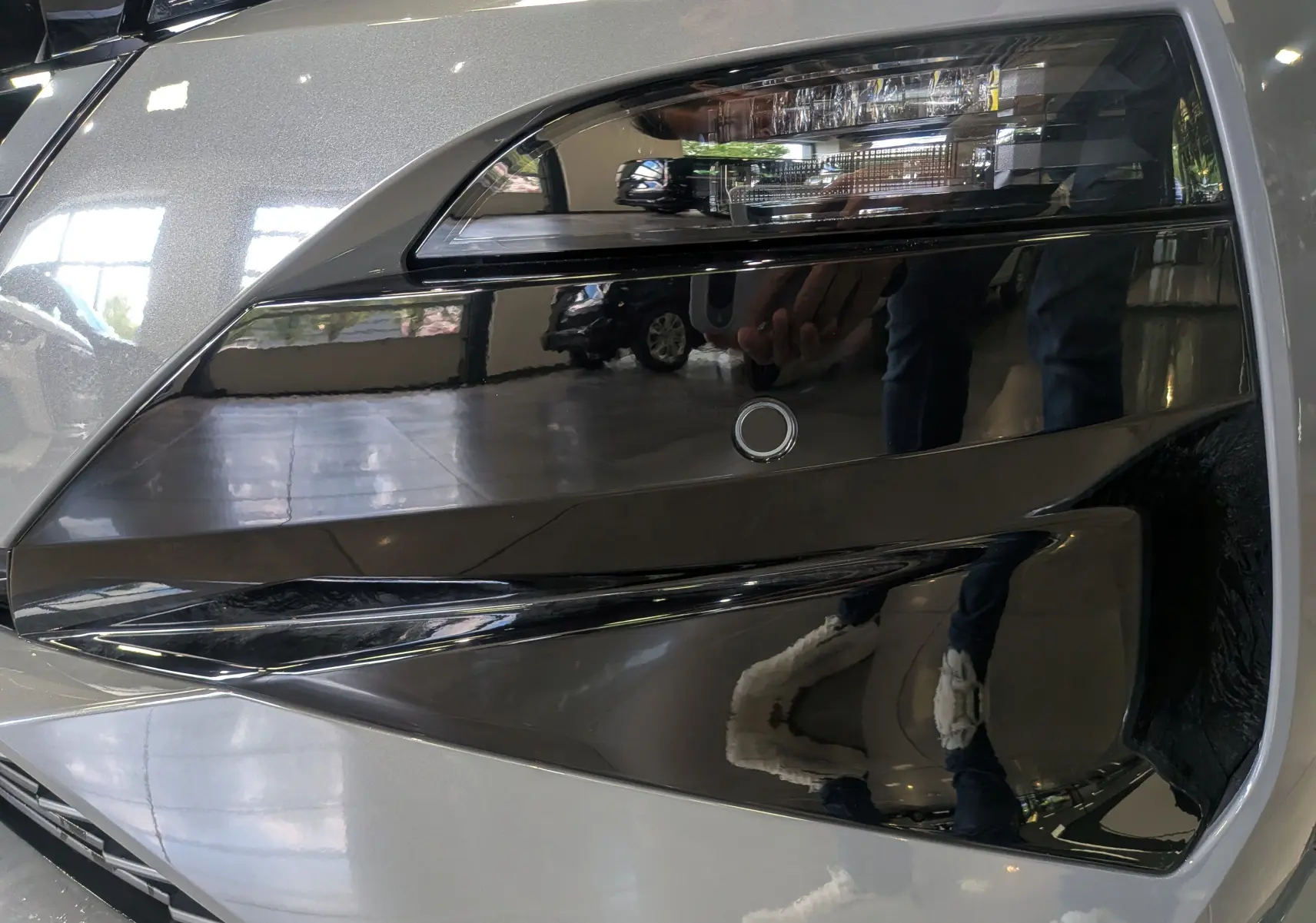 Gros plan sur le phare avant droit gris Sélénium du Peugeot 308 2026, soulignant ses détails LED et son design moderne.