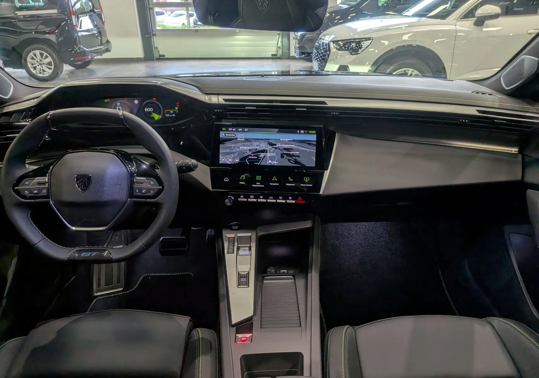 Vue intérieure avant de la Peugeot 308 GT Exclusive 2026, tableau de bord noir avec écran tactile et volant compact GT.