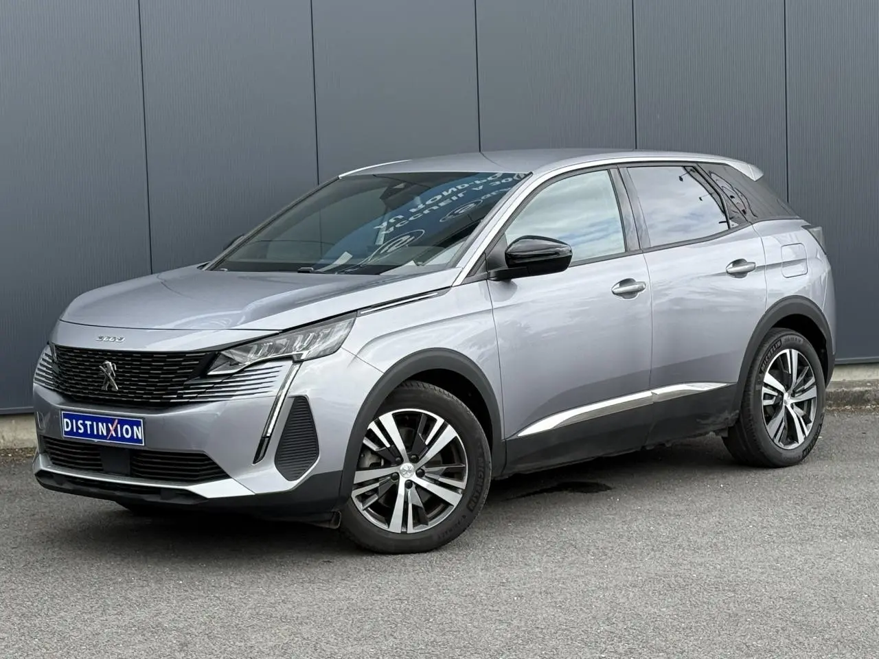 Peugeot 3008 gris Artense en 3/4 avant droit, avec jantes alliage bi-ton et calandre noire distinctive.