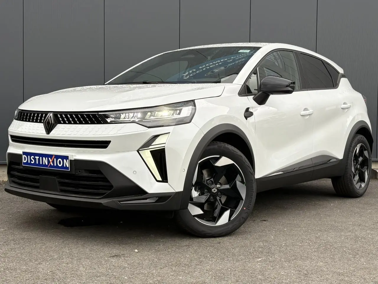 Renault Captur blanc nacré en 3/4 avant droit, avec jantes aluminium noires et rétroviseurs noirs brillants.