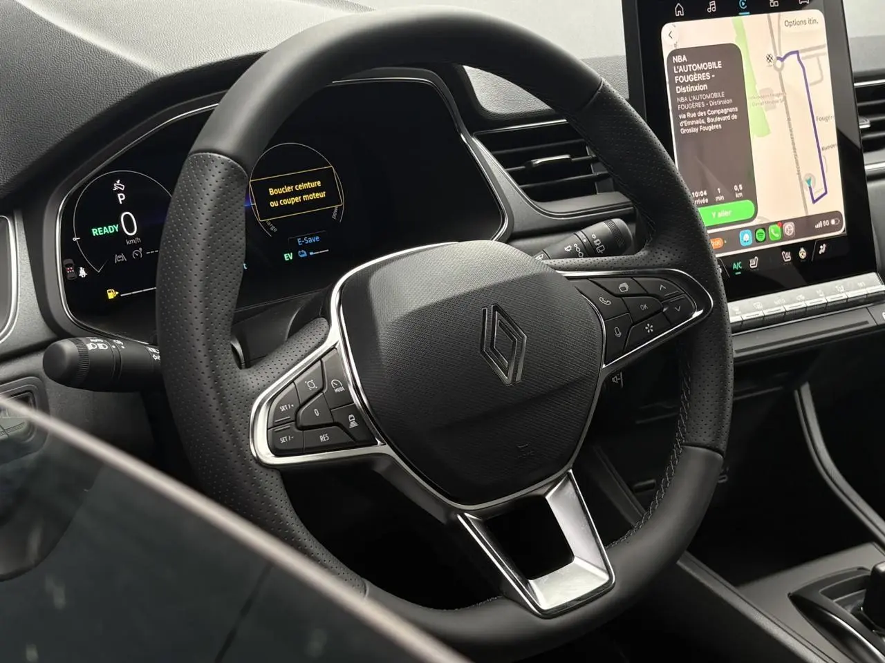Vue rapprochée du volant noir perforé et du tableau de bord numérique du Renault Captur 2026 avec écran tactile central.