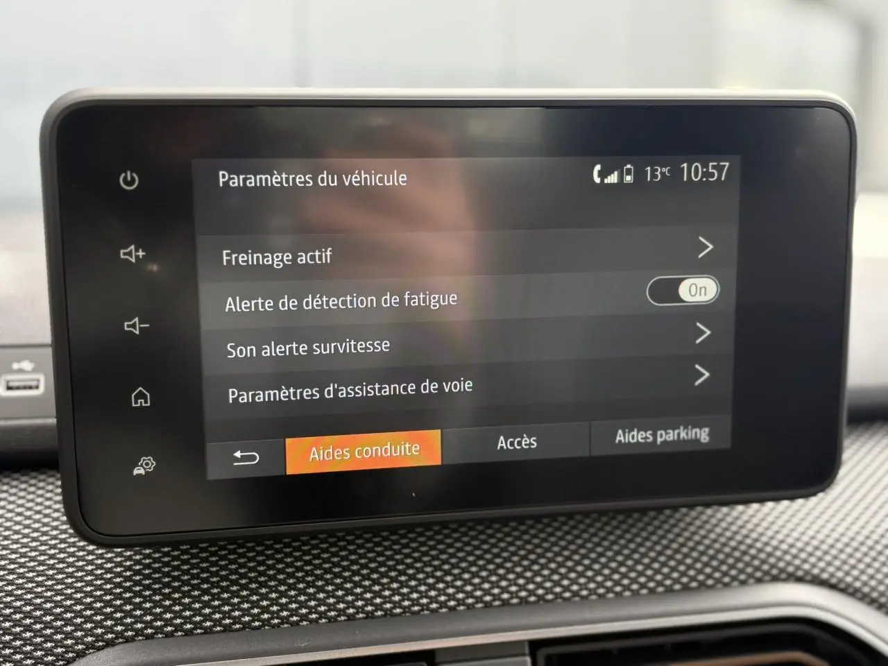 Écran tactile central du tableau de bord de la Dacia Sandero Stepway gris Schiste, affichant les paramètres d'aide à la conduite.