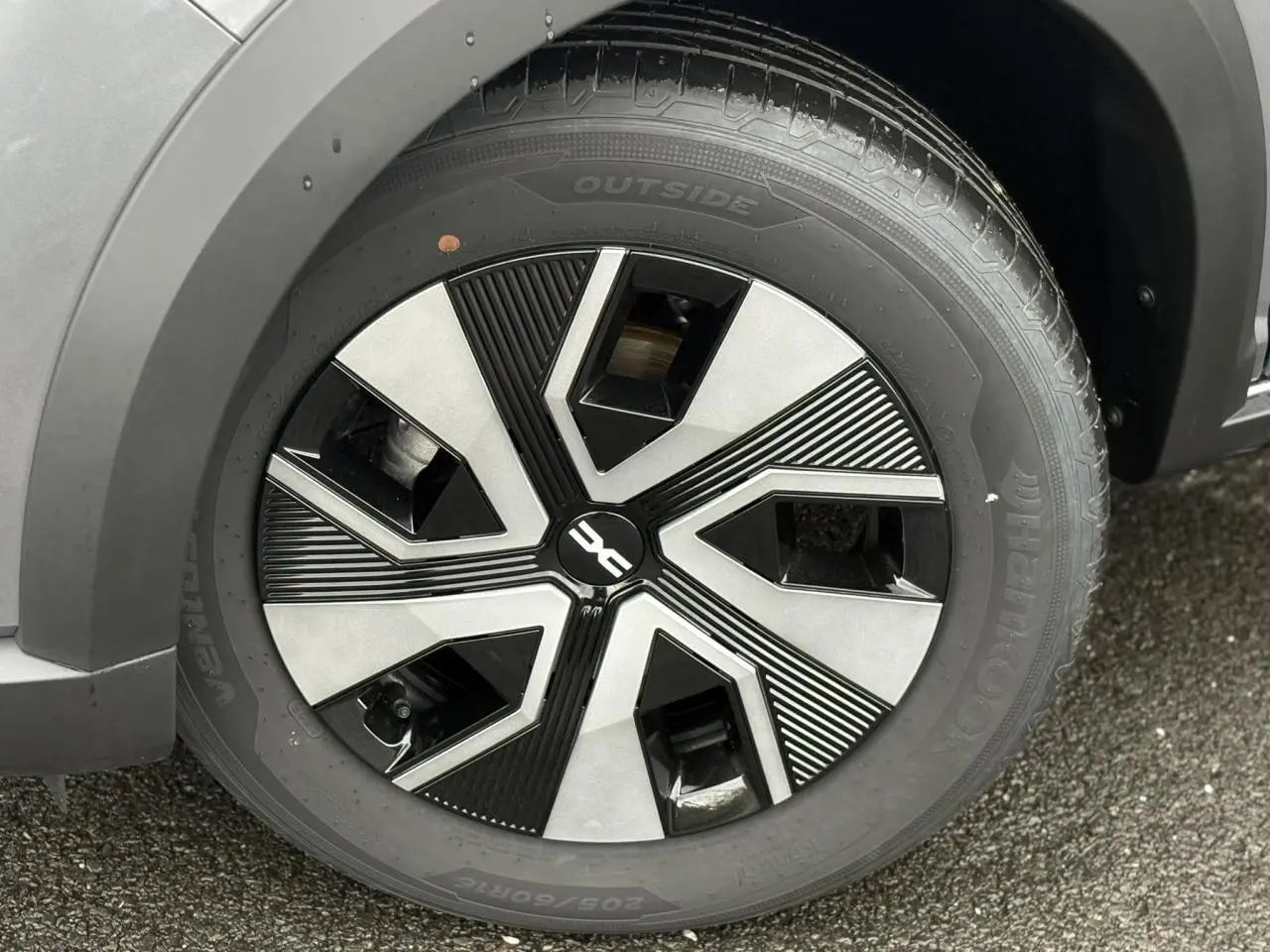 Gros plan sur la roue avant droite du Dacia Sandero Stepway gris schiste avec jante Atara Dark 16 pouces.