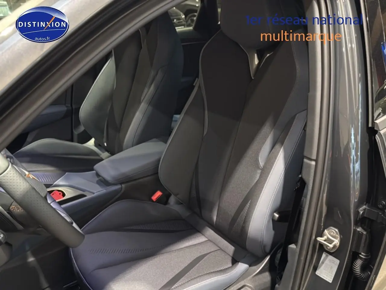 Vue intérieure côté conducteur du CUPRA Terramar gris 2025, mettant en valeur les sièges sport noirs et l'accoudoir central.