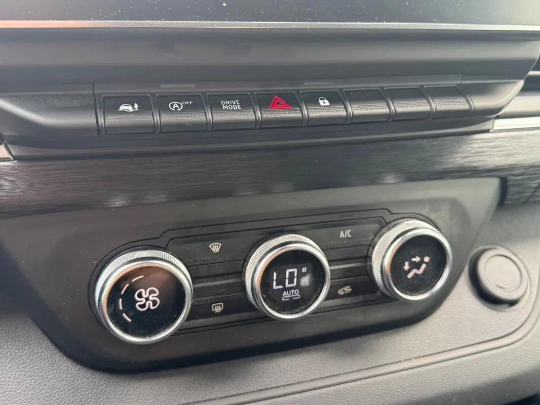 Gros plan sur la console centrale du Renault Trafic Fourgon gris foncé, montrant les commandes de climatisation et les boutons de fonction.