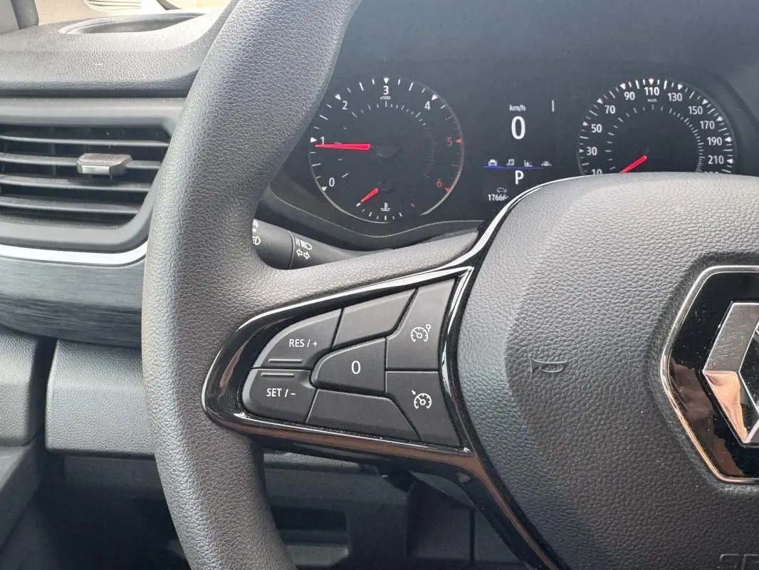 Vue rapprochée du volant gris foncé du Renault Trafic Fourgon 2024 avec commandes intégrées au volant.