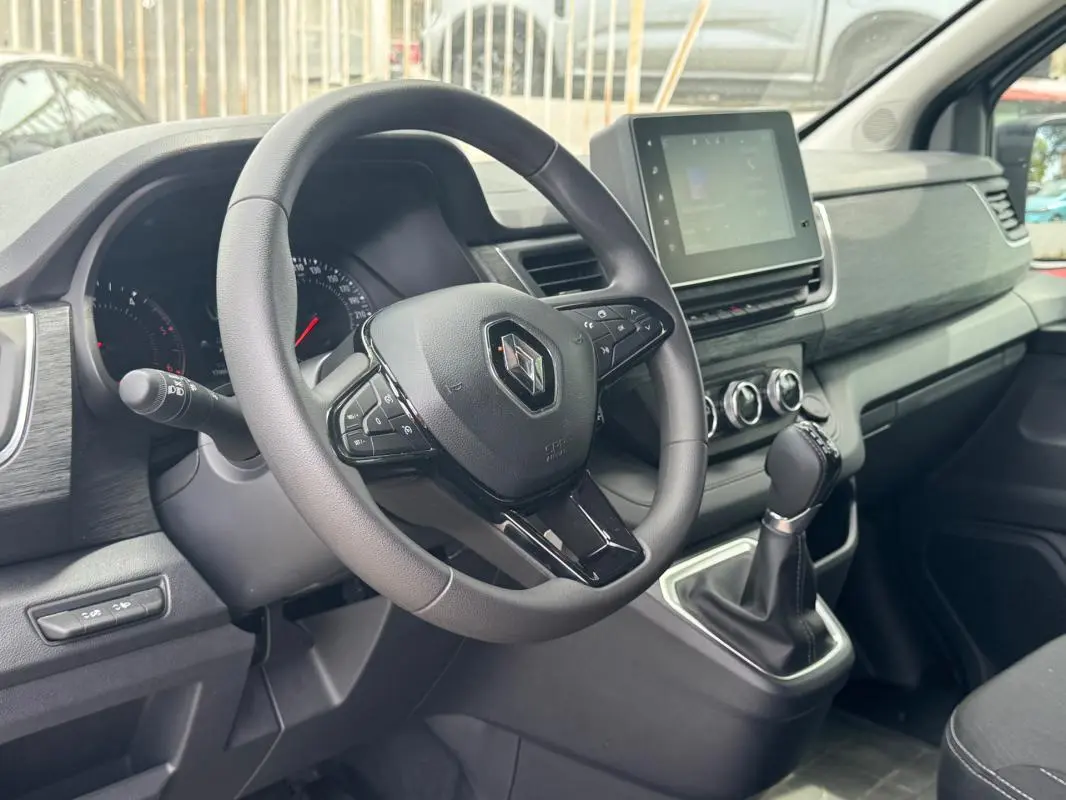 Vue intérieure côté conducteur du Renault Trafic Fourgon 2024, montrant le volant, tableau de bord et écran tactile.
