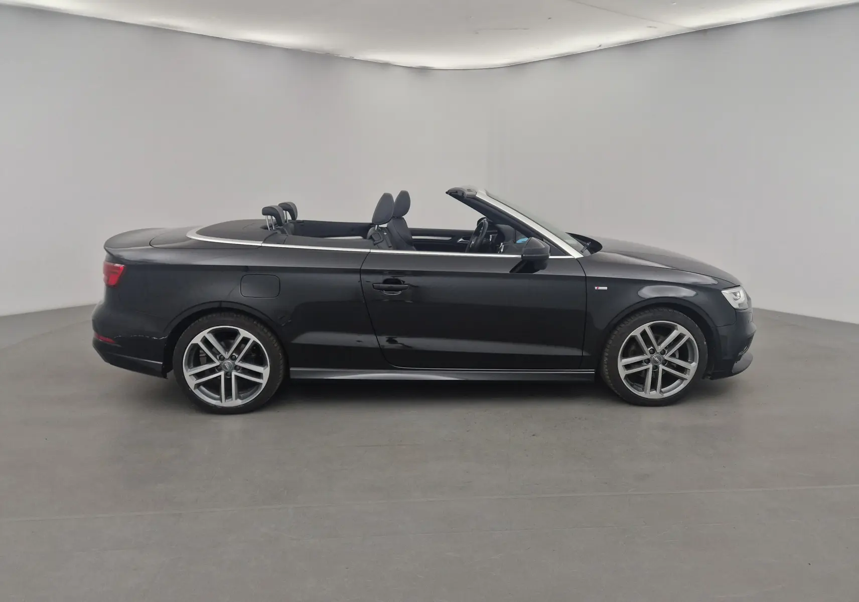 Audi A3 Cabriolet noir vue de profil côté gauche, capote ouverte et jantes alliage 18 pouces S-Line.