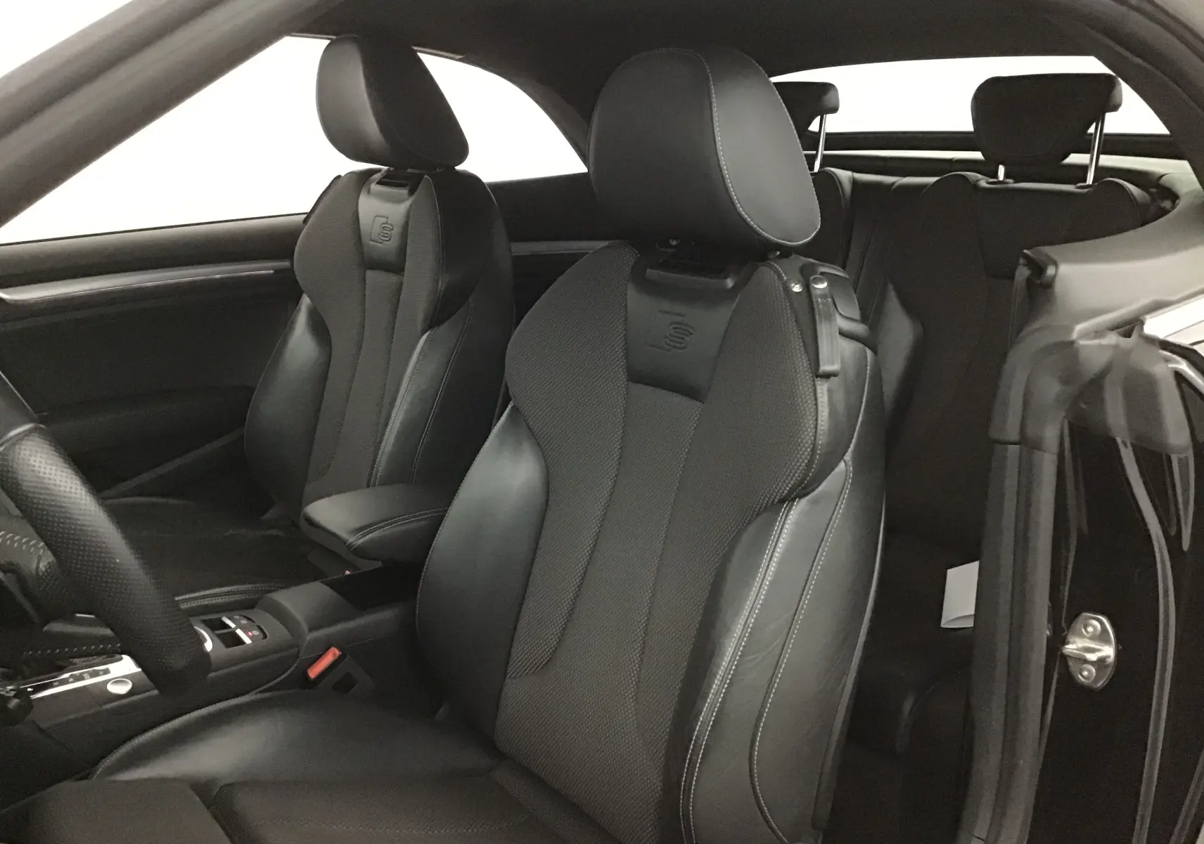 Intérieur noir de l'Audi A3 Cabriolet 2020, vue côté conducteur sur les sièges sport S-LINE en cuir avec surpiqûres blanches.