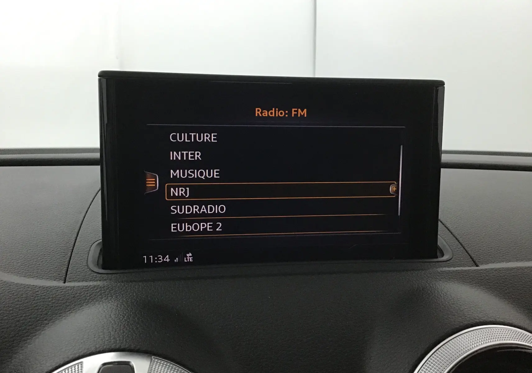 Écran central de l'Audi A3 Cabriolet 2020 affichant les options radio FM avec interface noire et orange.