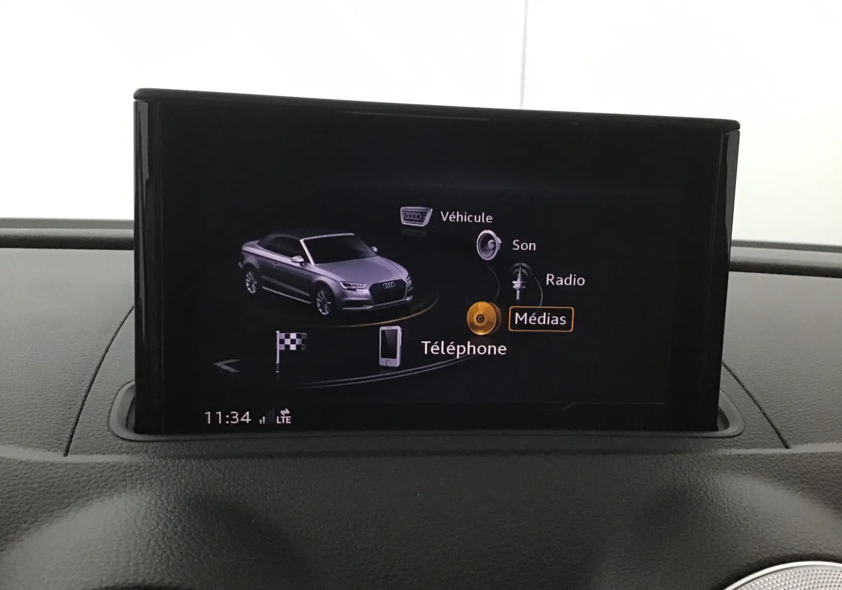 Écran central affichant le menu multimédia avec une miniature grise de l'Audi A3 Cabriolet vue de face.