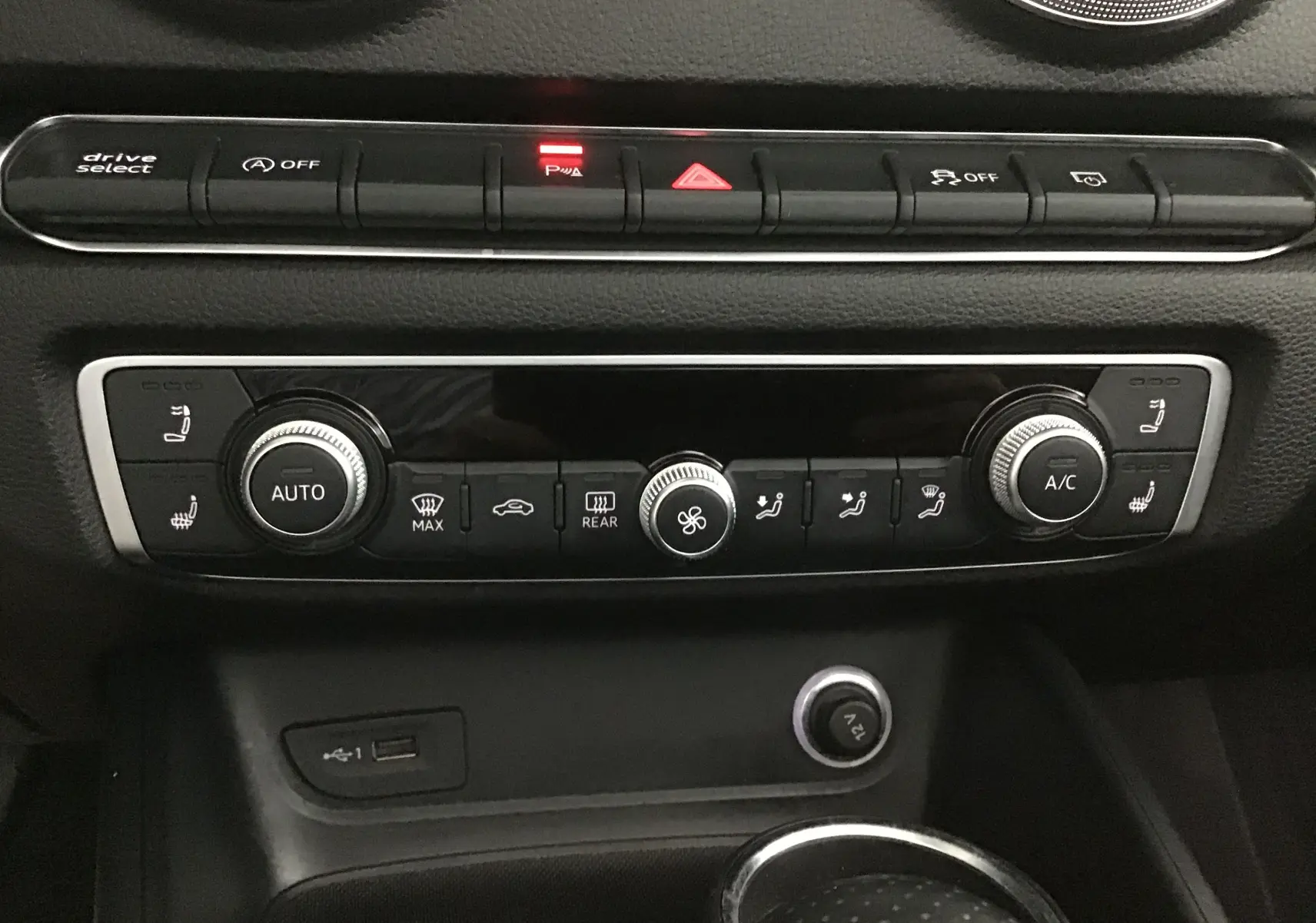Vue rapprochée de la console centrale de l'Audi A3 Cabriolet 2020, montrant les commandes de climatisation et les boutons de fonction.