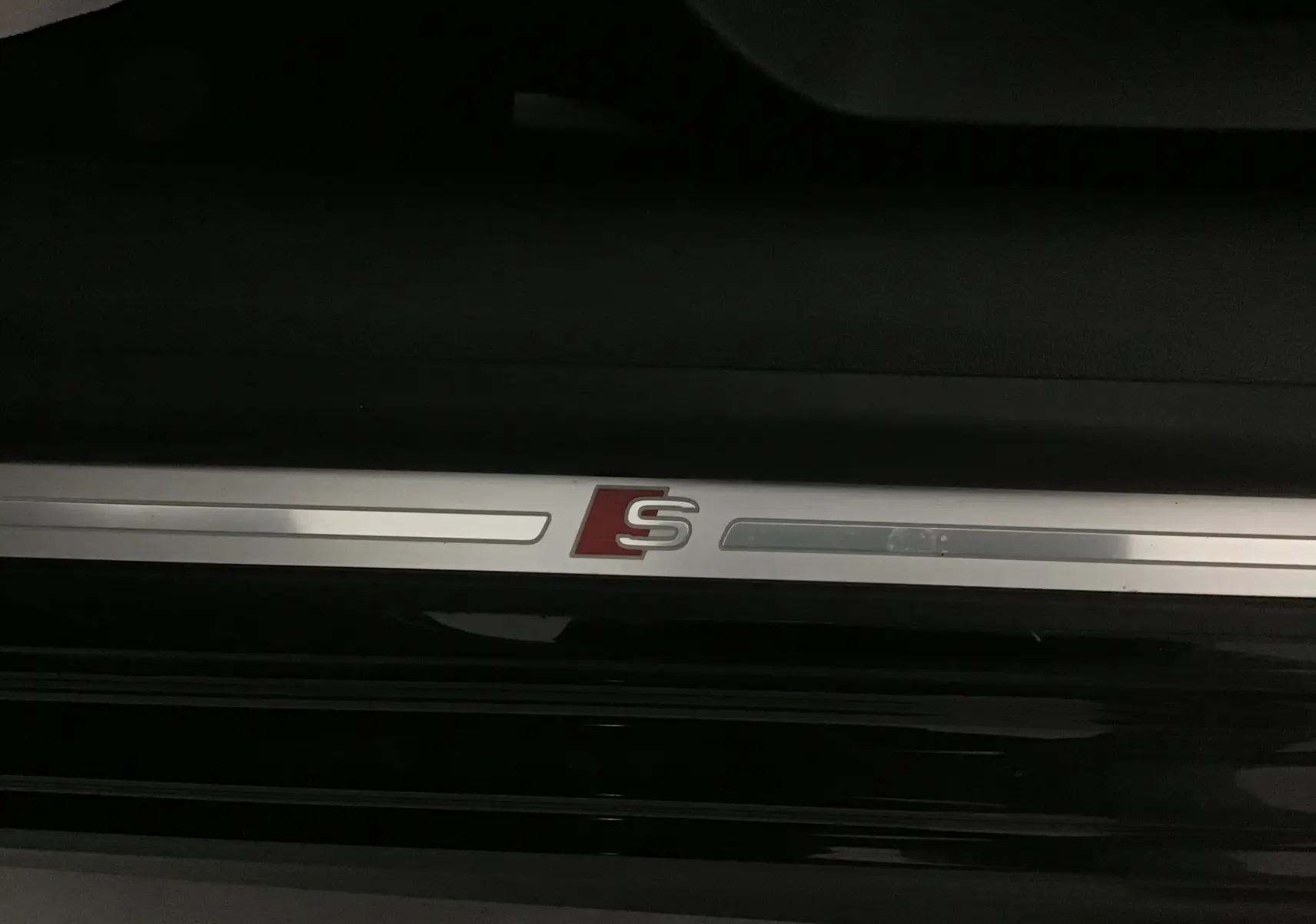 Seuil de porte avec logo S rouge sur Audi A3 Cabriolet noir, détail intérieur côté gauche.