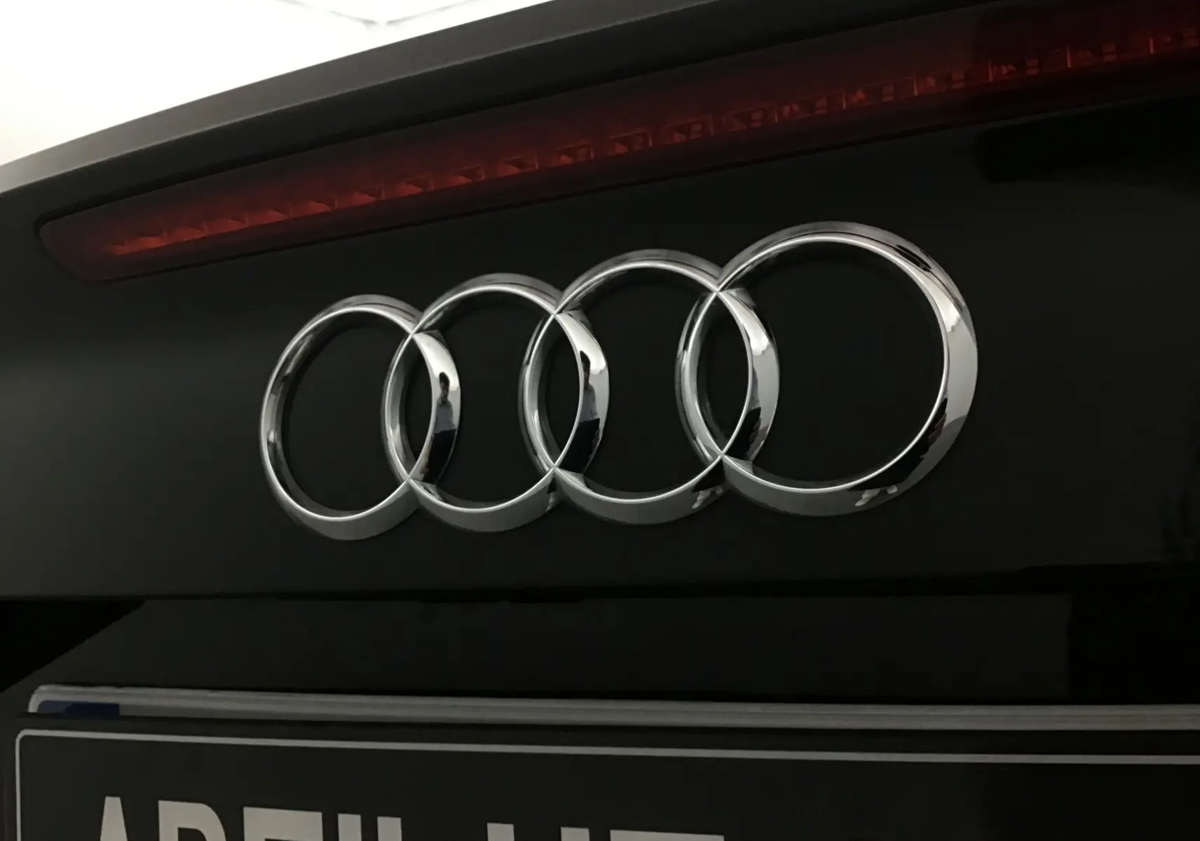 Gros plan sur l'arrière noir d'une Audi A3 Cabriolet 2020, mettant en valeur l'emblème Audi chromé et le feu stop supérieur.