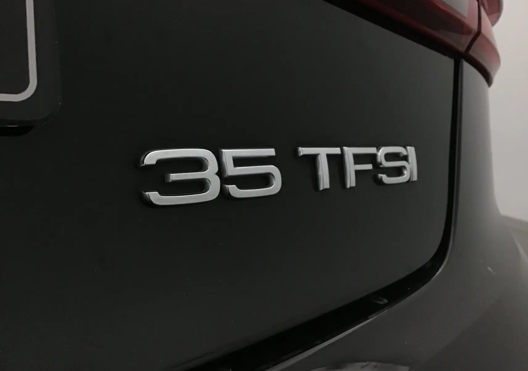 Gros plan sur l'arrière noir d'une Audi A3 Cabriolet 1.5 TFSI avec l'insigne "35 TFSI" en chrome.