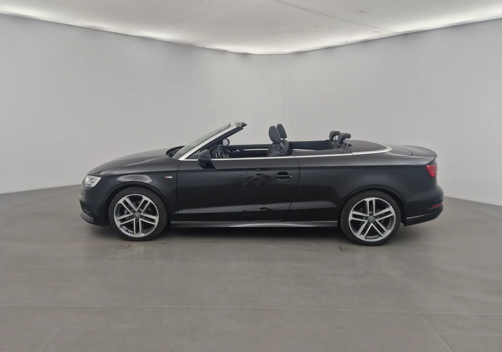 Audi A3 Cabriolet noir vue de profil côté gauche, capote électrique ouverte et jantes alliage 18 pouces.