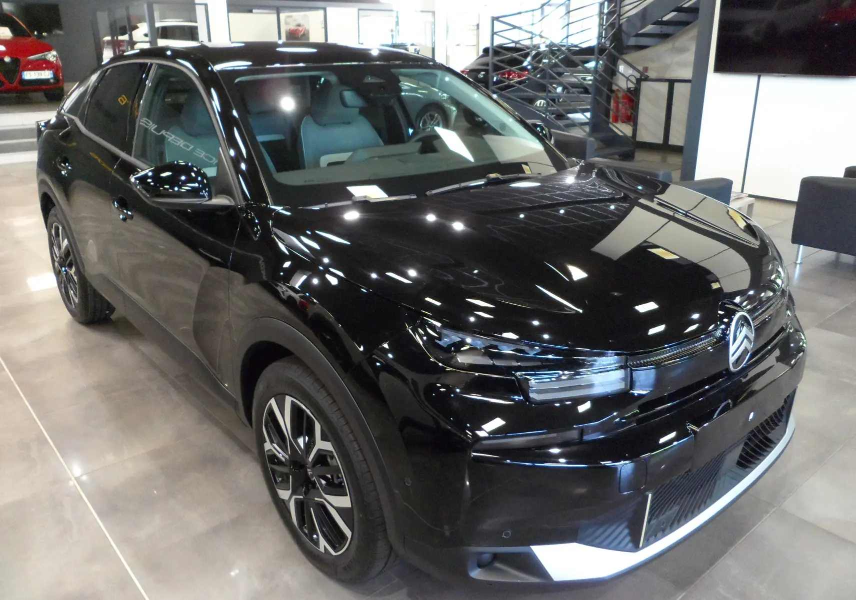 Citroën C4 Hybride 136 e-DCS6 Max noir Perla vue 3/4 avant droit en intérieur showroom, jantes alliage et phares LED.