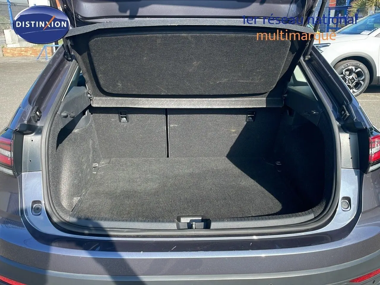 Coffre ouvert en vue arrière d'un Volkswagen Taigo gris cendre 2022, montrant un espace de chargement vide et propre.