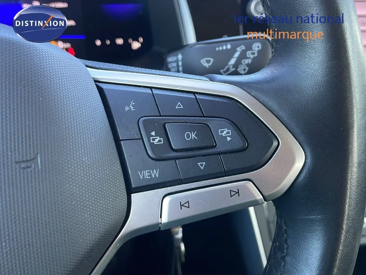 Gros plan sur les commandes multifonctions côté gauche du volant noir du Volkswagen Taigo gris cendre 2022.