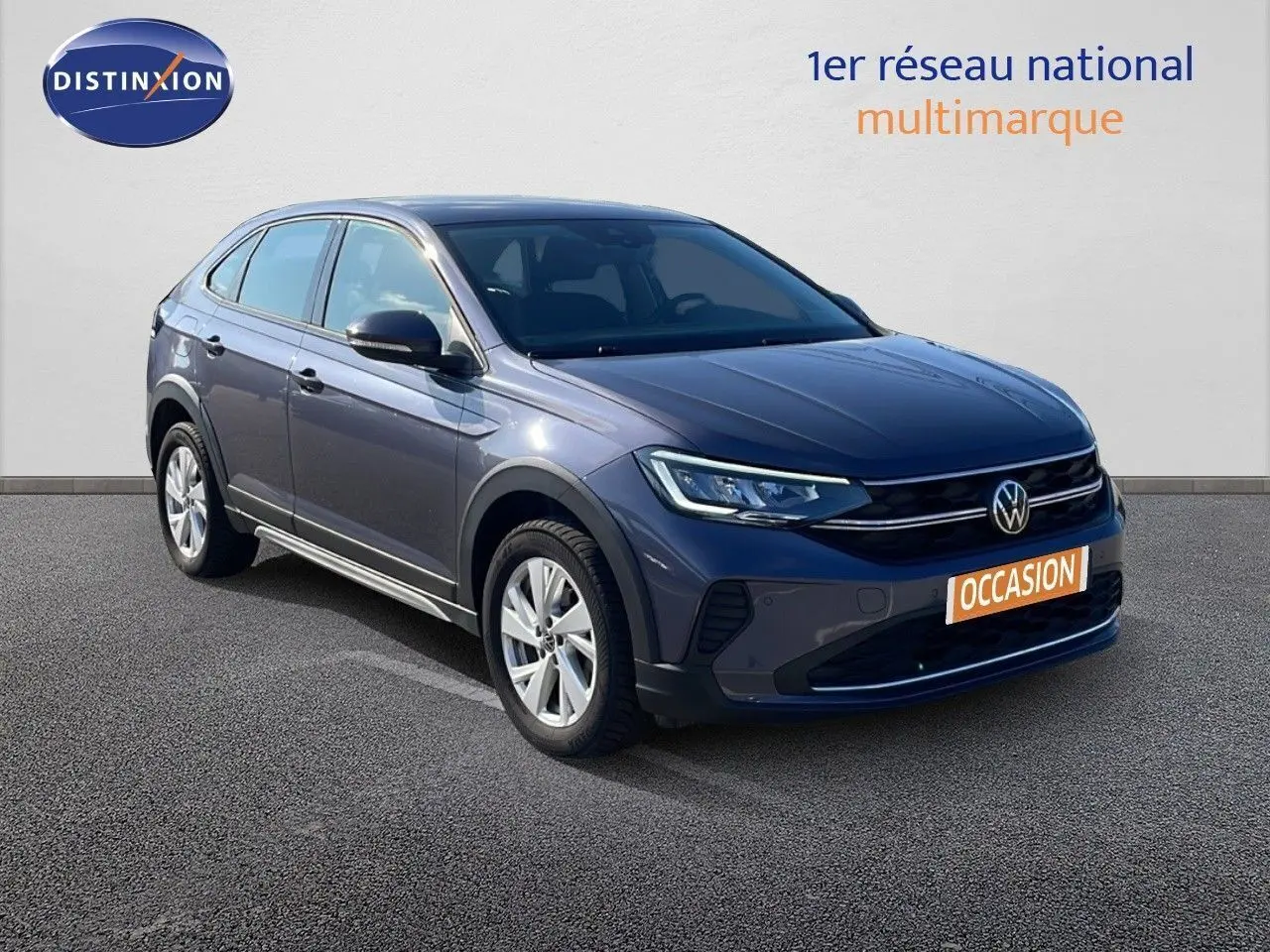 Volkswagen Taigo gris cendre en 3/4 avant droit, avec jantes alliage et calandre noire brillante.