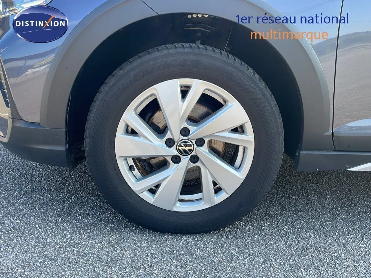 Gros plan sur la roue avant gauche d'un Volkswagen Taigo gris cendre, soulignant la jante alliage 16 pouces.