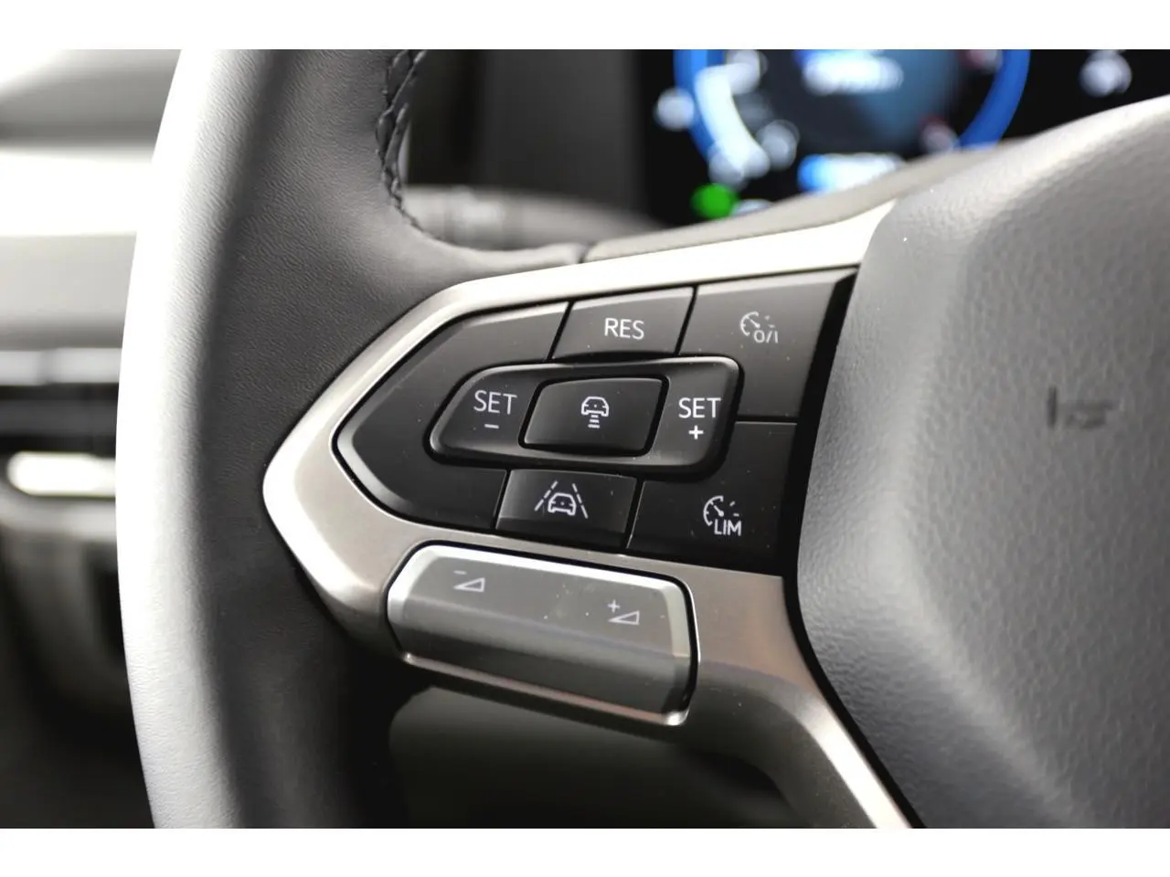 Gros plan sur les commandes multifonctions du volant du Volkswagen Transporter T7 Business gris Stone, 2025.