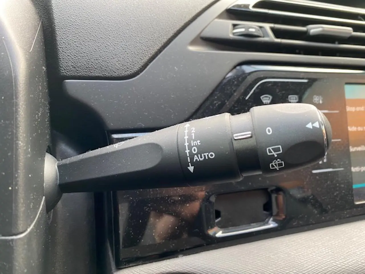 Gros plan sur la commande d'essuie-glace à gauche du volant dans l'habitacle du Citroën C4 Spacetourer gris Artense.