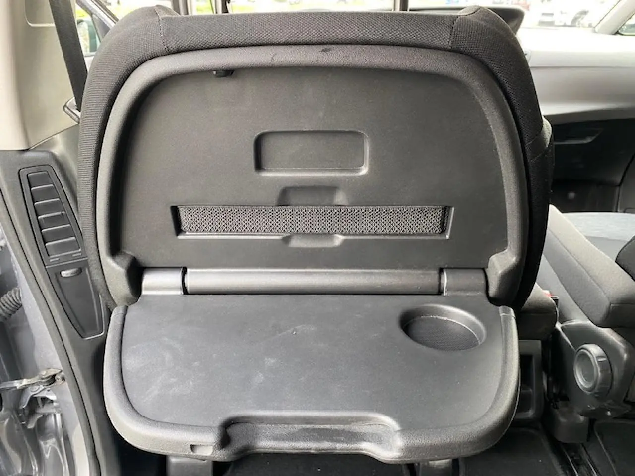 Tablette rabattable noire avec porte-gobelet intégrée au dos d'un siège arrière d'un Citroën C4 Spacetourer gris Artense.