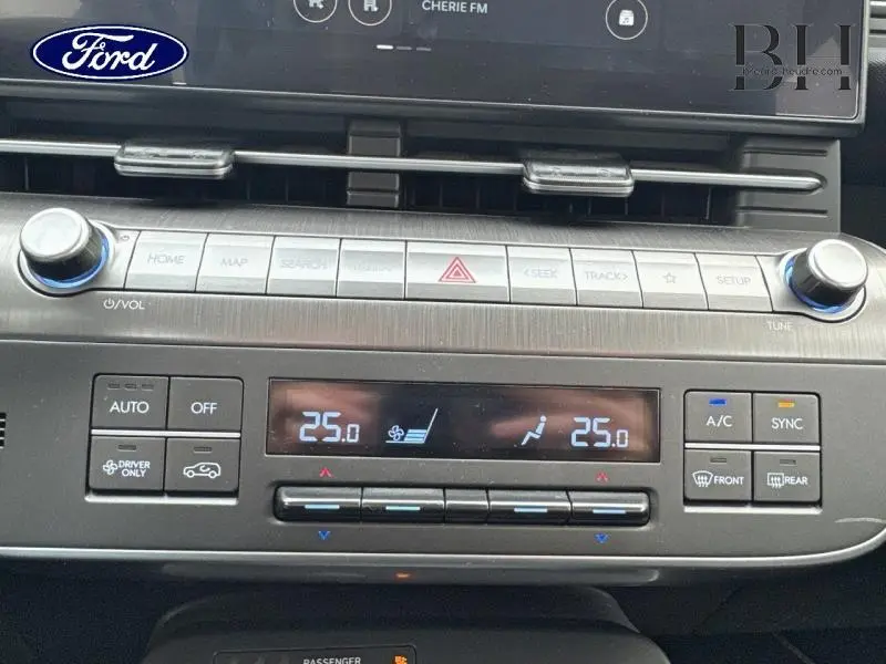 Tableau de bord du Hyundai Kona 2023 en Denim Blue, montrant les commandes de climatisation automatique bi-zone et écran tactile.