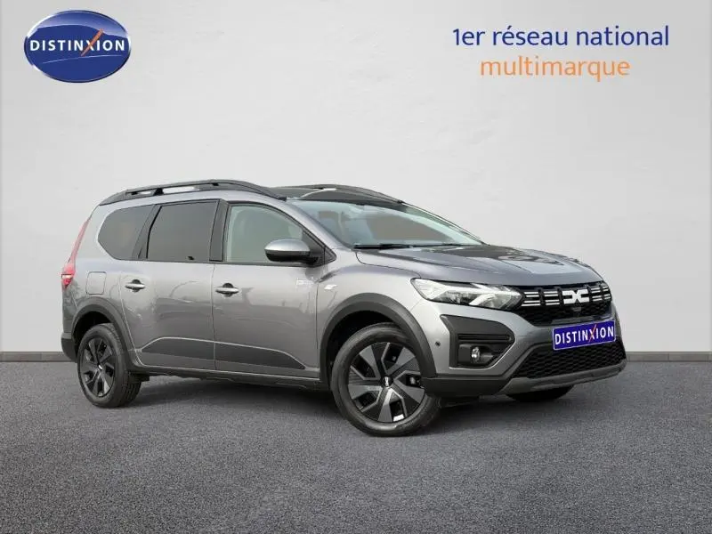 Vue 3/4 avant droit du Dacia Jogger gris schiste métallisé, version 7 places avec détails noirs contrastants.