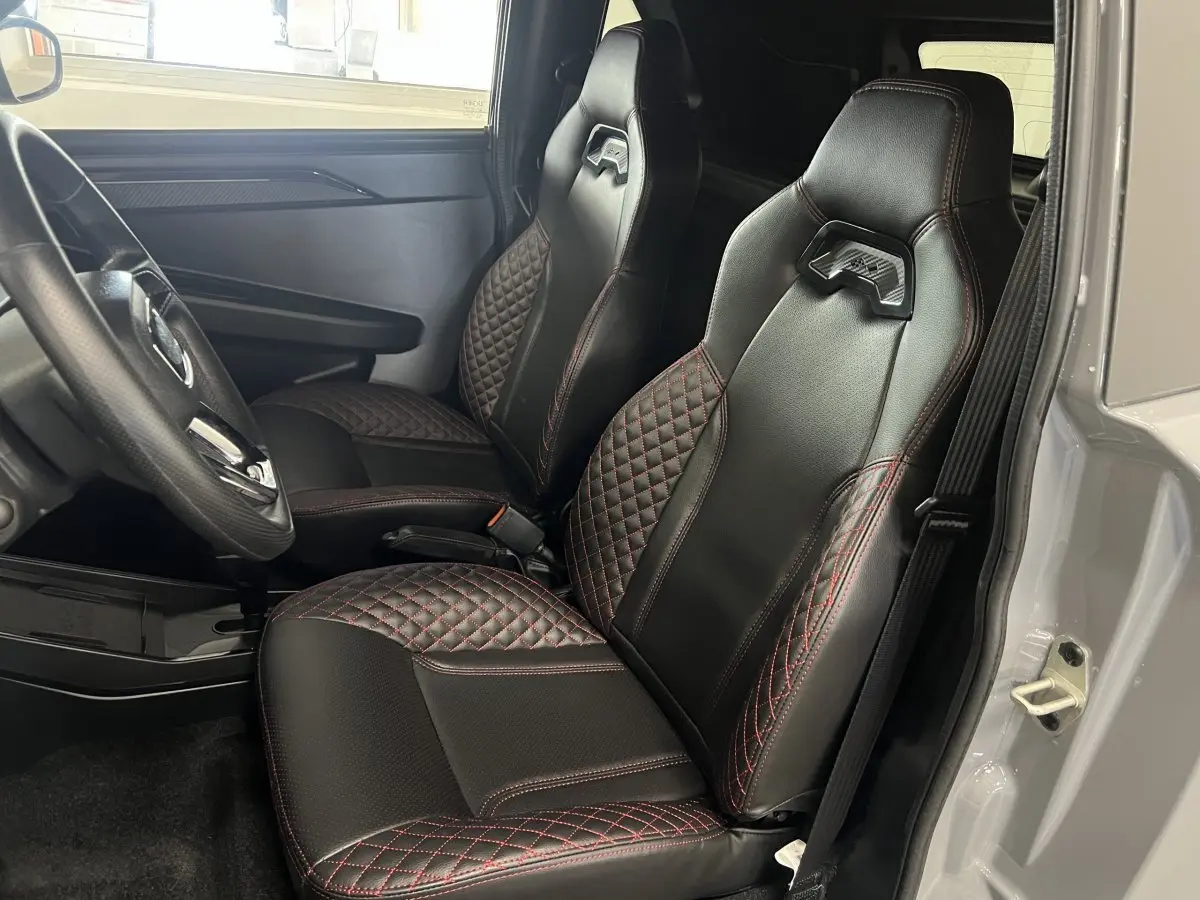 Vue intérieure côté conducteur montrant les sièges noirs avec surpiqûres rouges du Ligier JS50 0.5 REVO D+ Ultimate 2026.