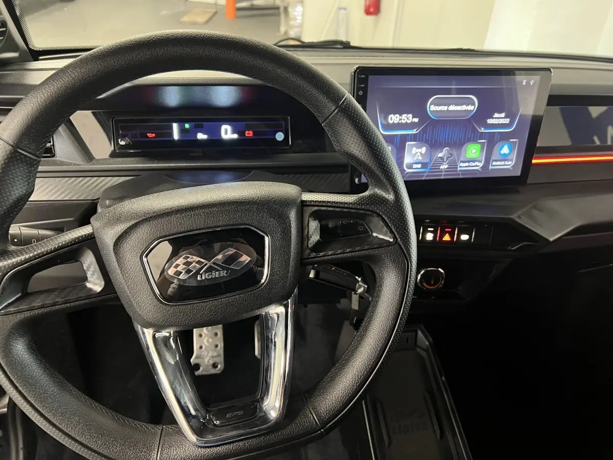 Vue intérieure centrée sur le volant et le tableau de bord numérique de la LIGIER JS50 0.5 REVO D+ ULTIMATE.