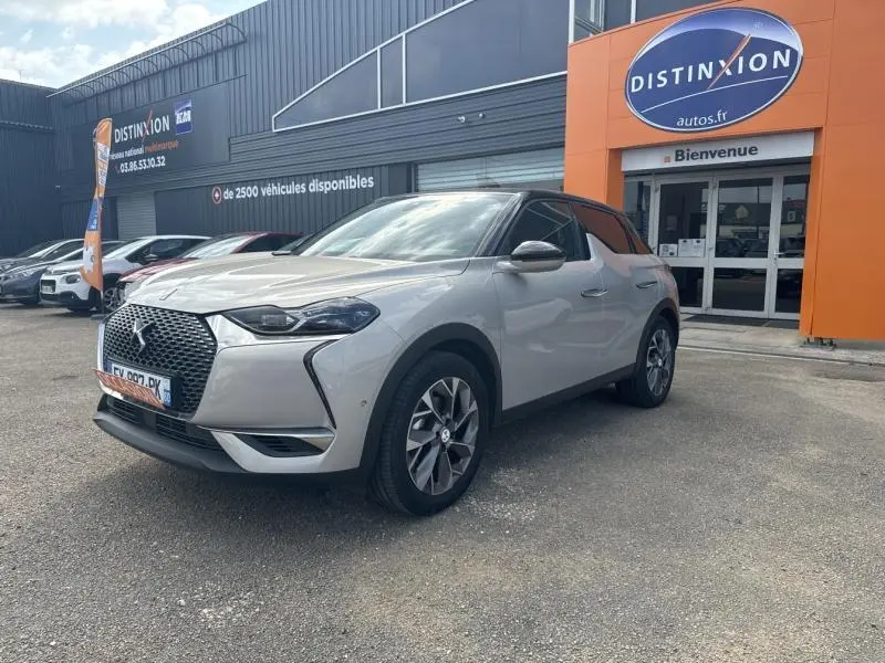 DS3 Crossback E-Tense Grand Chic gris Platinium avec toit noir Perla Nera, vue 3/4 avant sur parking devant concession.
