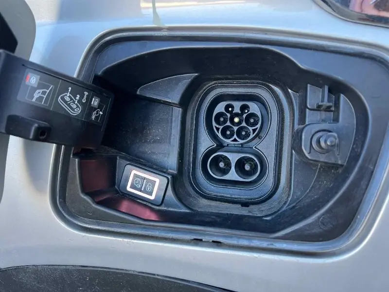Prise de recharge électrique ouverte côté gauche du DS3 Crossback E-Tense gris Platinium avec bouton de déverrouillage visible.