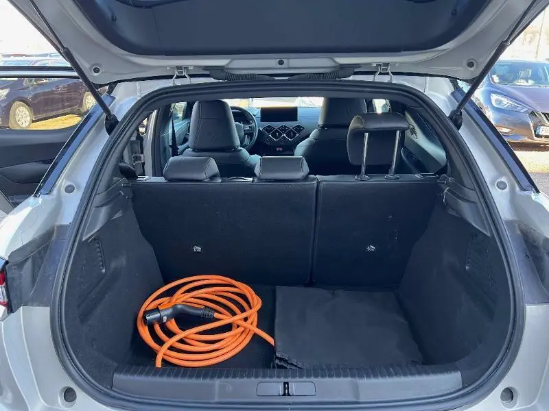 Coffre ouvert d'une DS3 Crossback E-Tense gris Platinium, avec câble de recharge orange visible à l'intérieur.