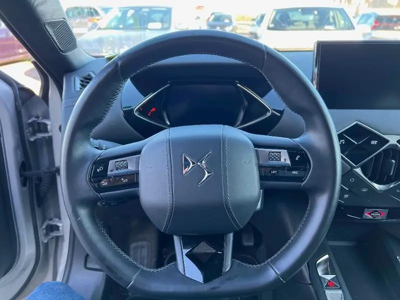 Vue intérieure centrée sur le volant cuir noir du DS3 Crossback E-Tense 2021 avec tableau de bord digital et écran tactile.