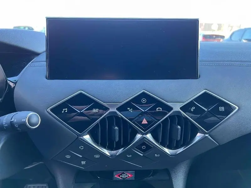 Tableau de bord du DS3 Crossback E-Tense 2021, montrant l'écran tactile et les commandes en losange noires sur fond gris.