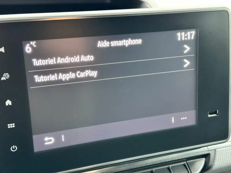 Écran tactile central du Nissan Townstar blanc minéral 2024 affichant les tutoriels Android Auto et Apple CarPlay.