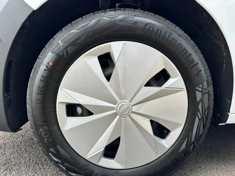 Gros plan sur la roue avant droite du Nissan Townstar blanc minéral avec enjoliveur au design géométrique.