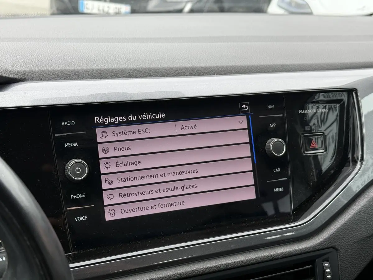 Écran tactile central affichant les réglages du véhicule dans l'habitacle d'une Volkswagen Polo bleue 2021.