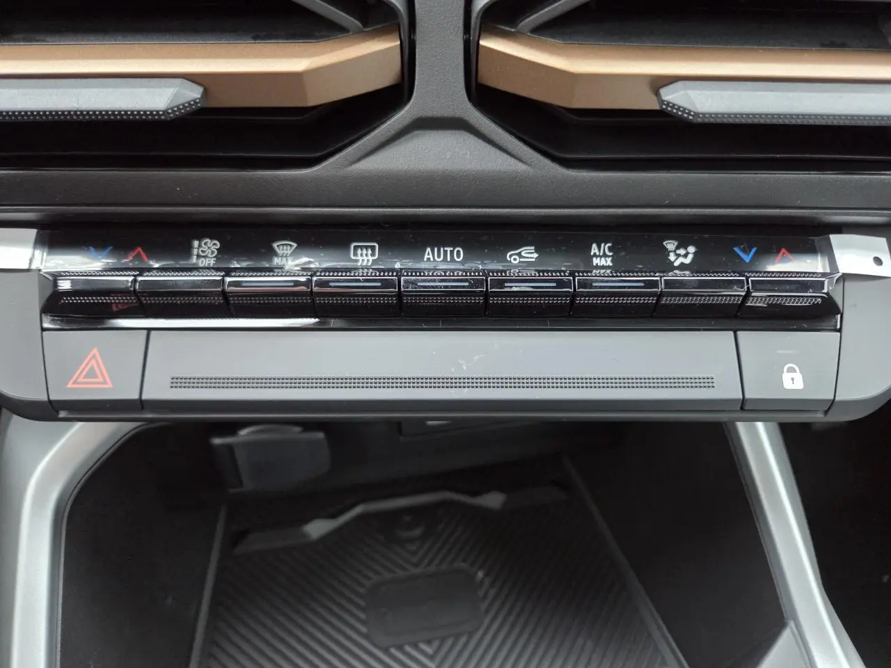 Gros plan sur la console centrale du Dacia Bigster 2025, avec commandes climatisation et détails brun cuivré visibles